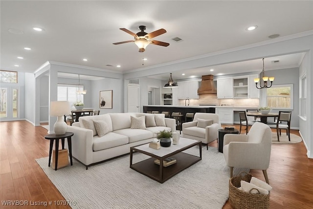 12200 Stonechase Dr, Fort Smith, AR 72916 - living room featuring a chandelier, baseboards, recessed lighting, light wood finished floors, and crown molding