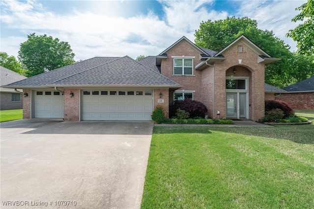traditional-style home with concrete driveway, brick siding, and a front lawn