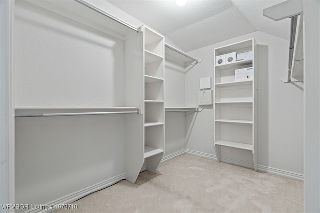 walk in closet featuring vaulted ceiling and carpet floors