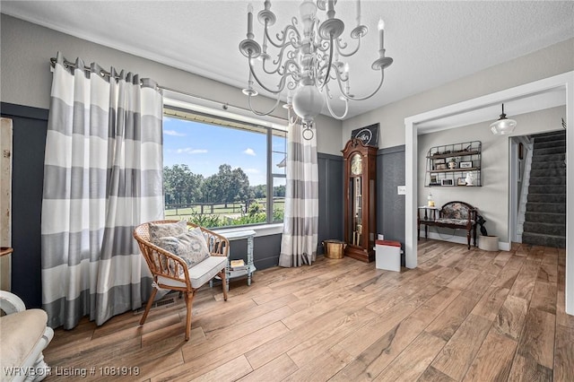 8807 Cain Rd, Alma, AR 72921 - living area with wood finished floors, a chandelier, a textured ceiling, and stairway