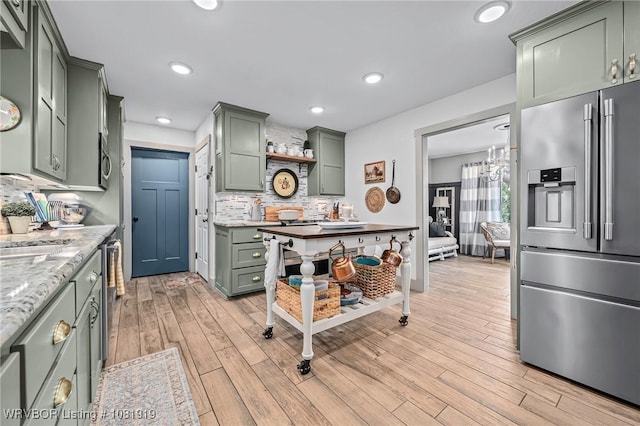 8807 Cain Rd, Alma, AR 72921 - kitchen featuring stainless steel fridge, green cabinetry, backsplash, light wood-type flooring, and recessed lighting
