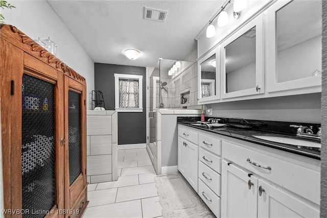 8807 Cain Rd, Alma, AR 72921 - full bathroom featuring a stall shower, double vanity, a textured ceiling, and tile patterned floors