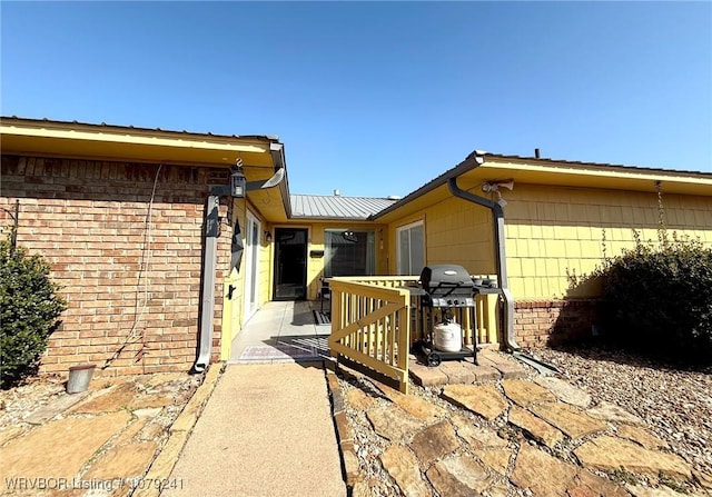 view of property exterior featuring brick siding and a patio area