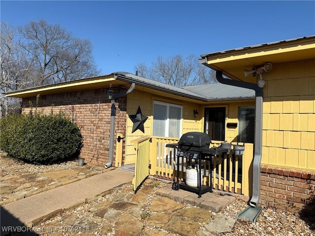 entrance to property with a patio and brick siding