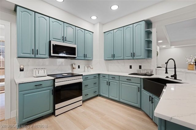 kitchen with sink, backsplash, light wood-type flooring, light stone countertops, and electric range