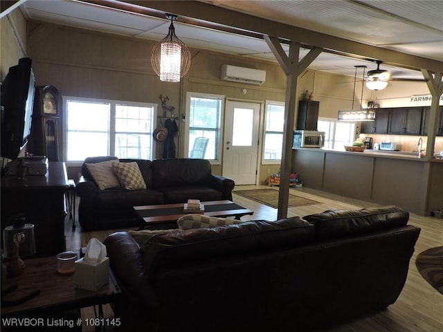 19108 Canova Trl, Mountainburg, AR 72946 - living room featuring an AC wall unit, wood finished floors, beamed ceiling, and a ceiling fan
