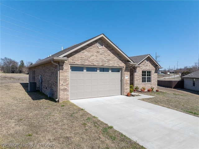 single story home with brick siding, a front lawn, central AC unit, a garage, and driveway