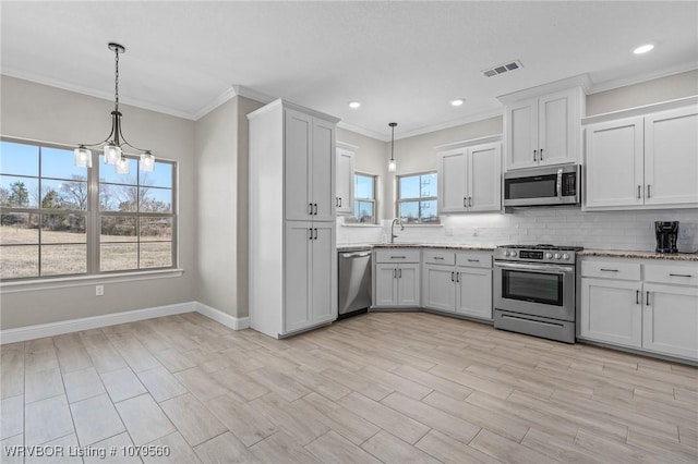 kitchen with visible vents, a sink, light stone counters, backsplash, and stainless steel appliances