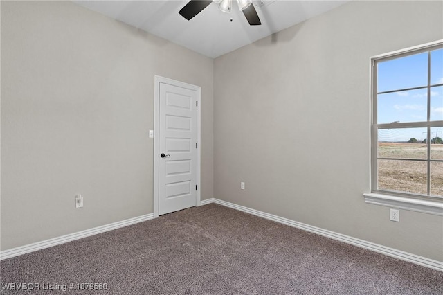 carpeted empty room featuring baseboards and a ceiling fan