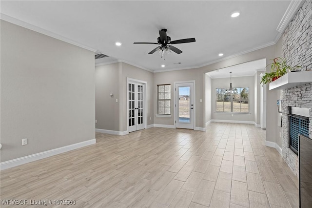 unfurnished living room with light wood finished floors, visible vents, baseboards, ceiling fan with notable chandelier, and a fireplace