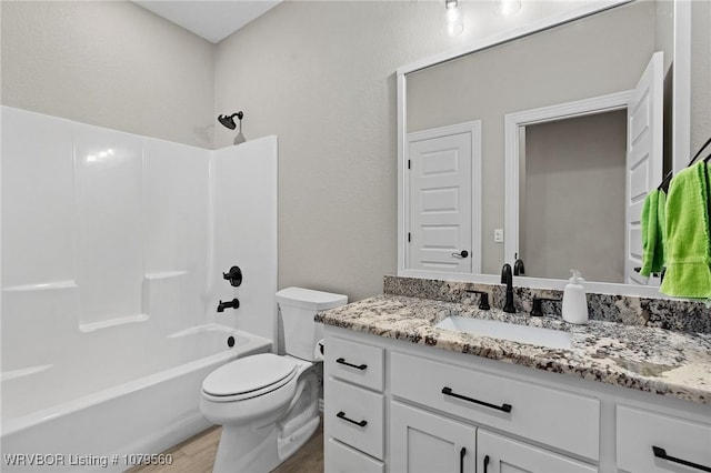 full bath with shower / bathing tub combination, toilet, wood finished floors, and vanity