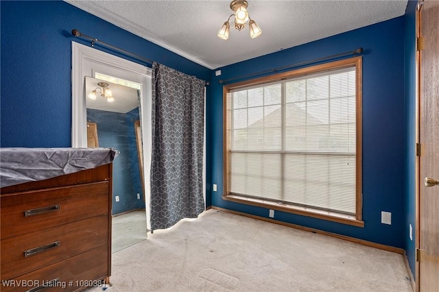 carpeted bedroom with a textured ceiling and baseboards