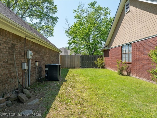 view of yard with fence and central AC