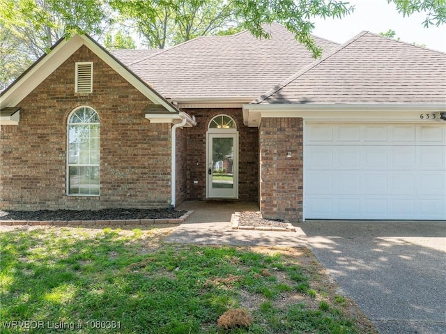 single story home featuring brick siding, an attached garage, a shingled roof, and driveway