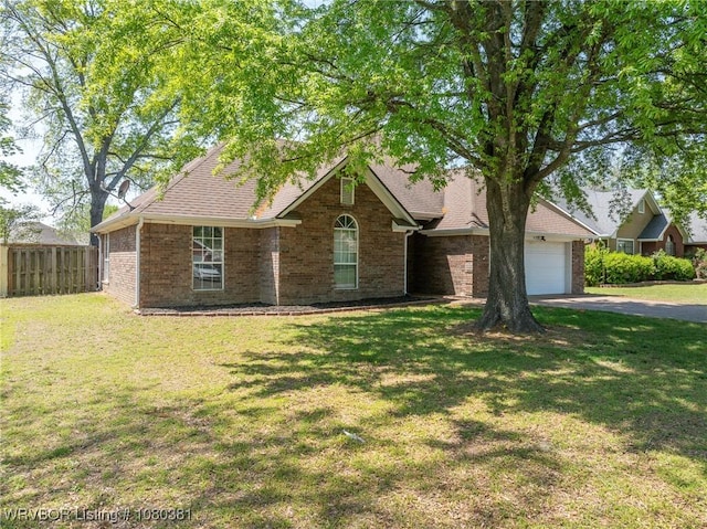 view of front of property featuring fence, a front lawn, driveway, and brick siding