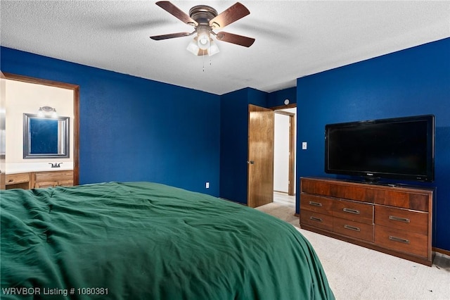 carpeted bedroom with ensuite bathroom and a ceiling fan