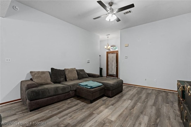 living room with wood finished floors, visible vents, baseboards, and ceiling fan with notable chandelier