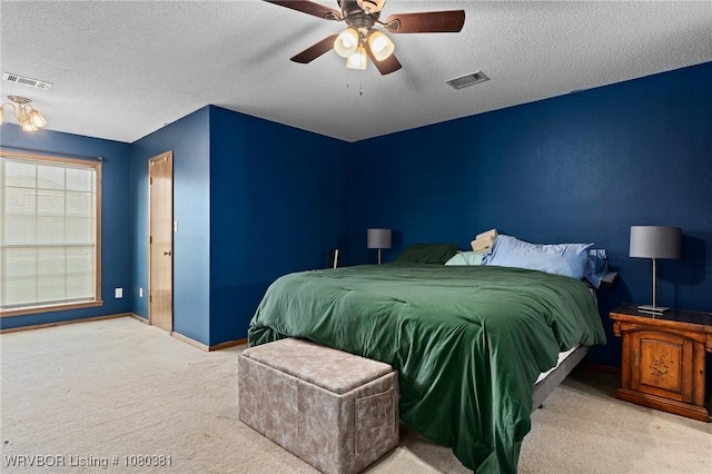 bedroom featuring baseboards, visible vents, carpet floors, and a textured ceiling