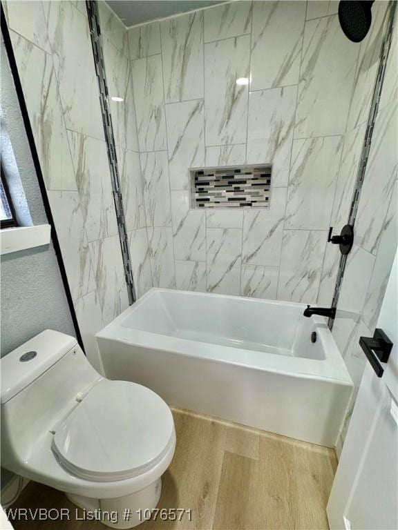 bathroom featuring hardwood / wood-style floors, toilet, and tiled shower / bath