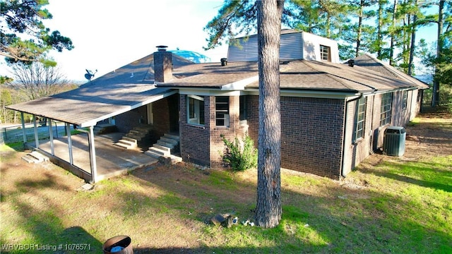 view of side of home featuring a patio area, central air condition unit, and a yard