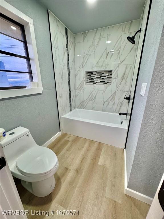 bathroom with toilet, tiled shower / bath combo, and hardwood / wood-style flooring