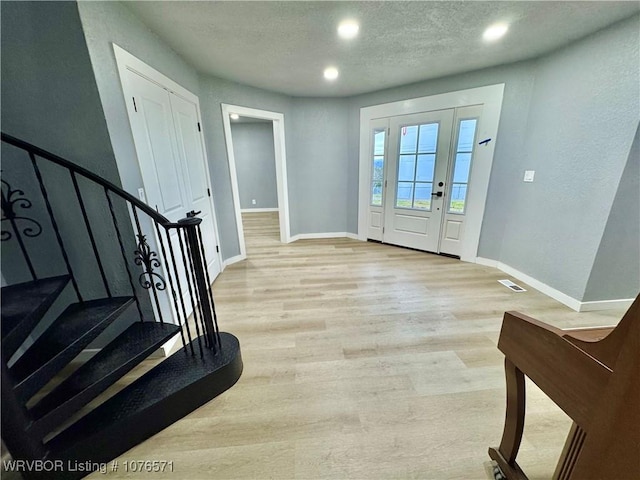 entrance foyer with a textured ceiling and light wood-type flooring