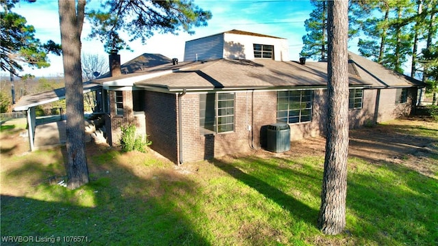 view of front of house with a front lawn and cooling unit