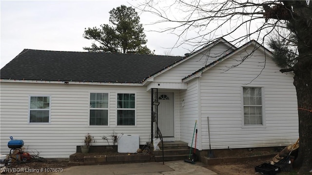 view of front of house with entry steps, roof with shingles, and a patio