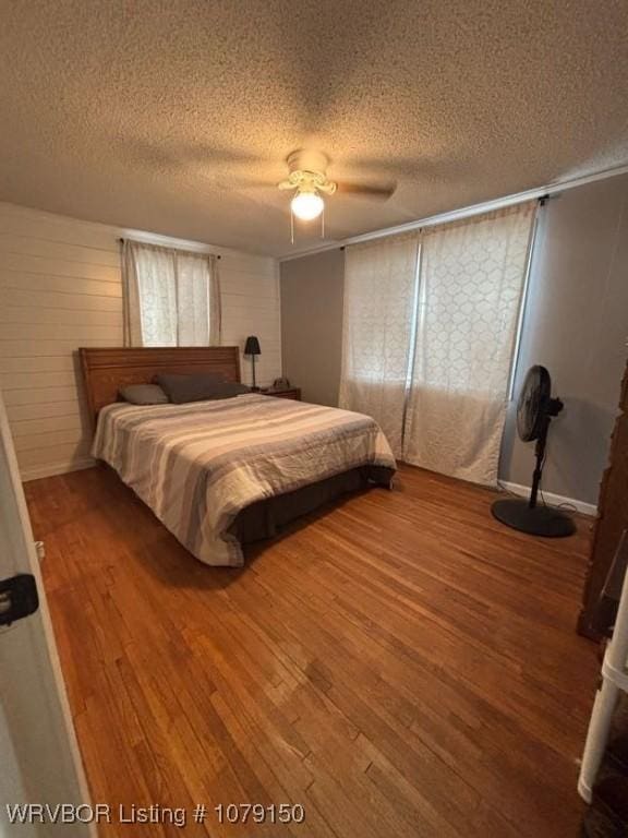 bedroom featuring ceiling fan, a textured ceiling, and wood finished floors