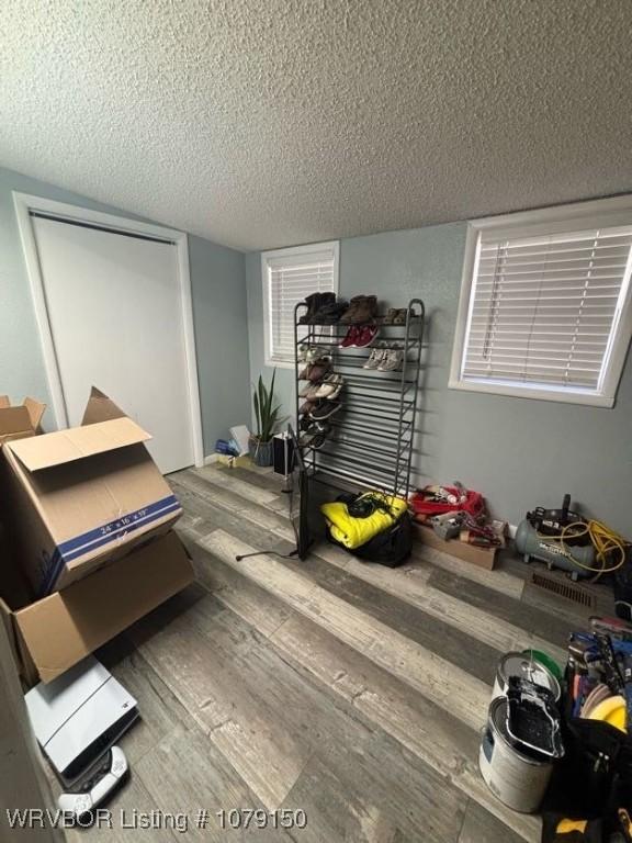 bedroom with a closet, a textured ceiling, and wood finished floors