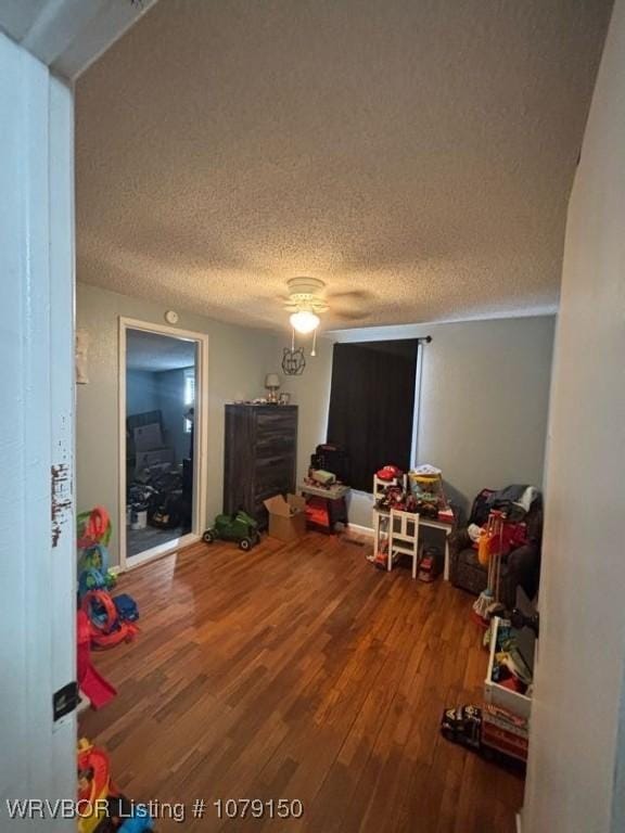 game room with a textured ceiling and wood finished floors