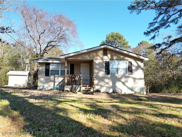 view of front of home featuring an outbuilding, a storage shed, and a front lawn