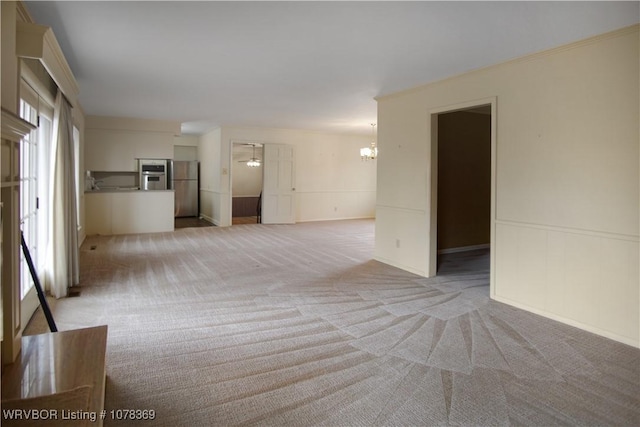 carpeted empty room with ceiling fan with notable chandelier