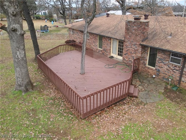 wooden terrace featuring a lawn and a trampoline