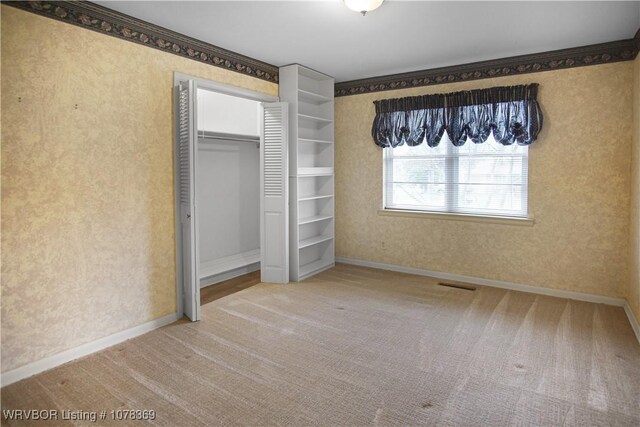 unfurnished bedroom featuring carpet and crown molding