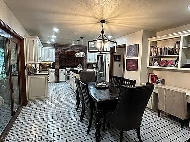 dining area featuring a textured ceiling and an inviting chandelier