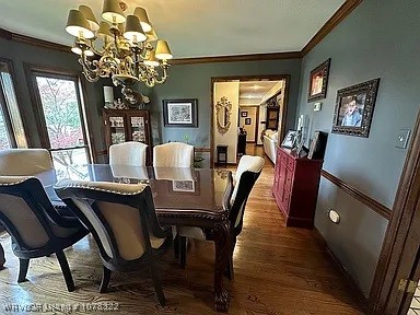 dining area featuring ornamental molding, dark hardwood / wood-style flooring, and a notable chandelier