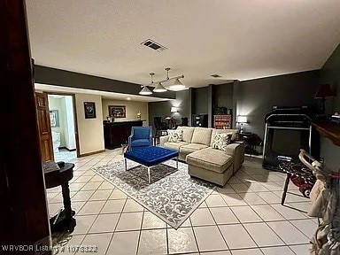 living room featuring light tile patterned floors and a textured ceiling