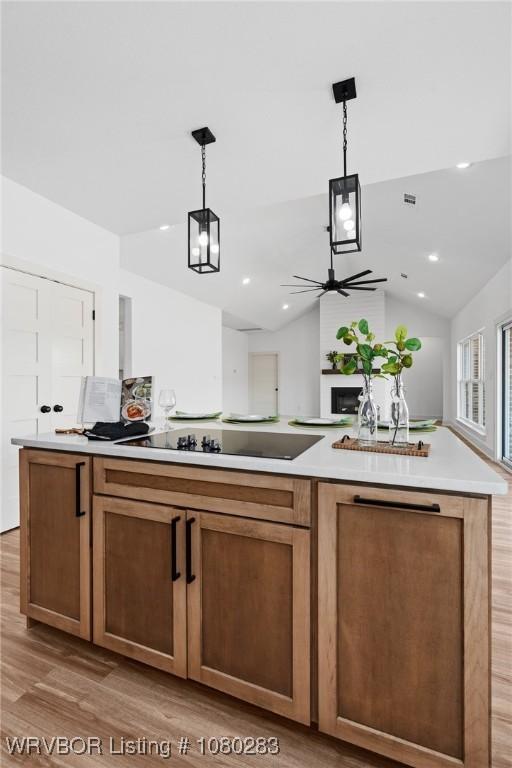 1900 Yellowstone Dr, Barling, AR 72923 - kitchen featuring decorative light fixtures, light countertops, light wood-type flooring, a ceiling fan, and a kitchen island