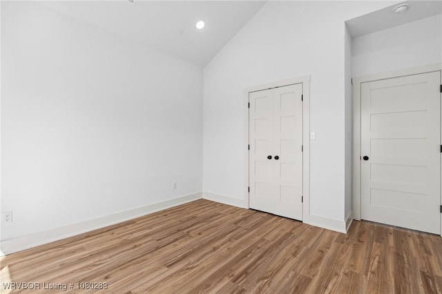 1900 Yellowstone Dr, Barling, AR 72923 - unfurnished bedroom featuring baseboards, recessed lighting, wood finished floors, and lofted ceiling