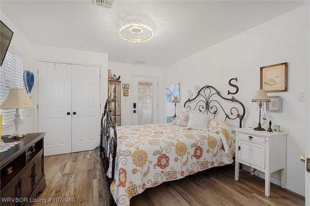 bedroom with a closet, hardwood / wood-style floors, and multiple windows