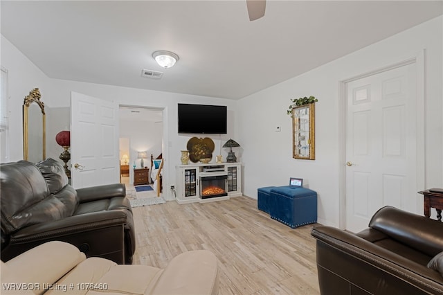 living room featuring ceiling fan and light hardwood / wood-style flooring