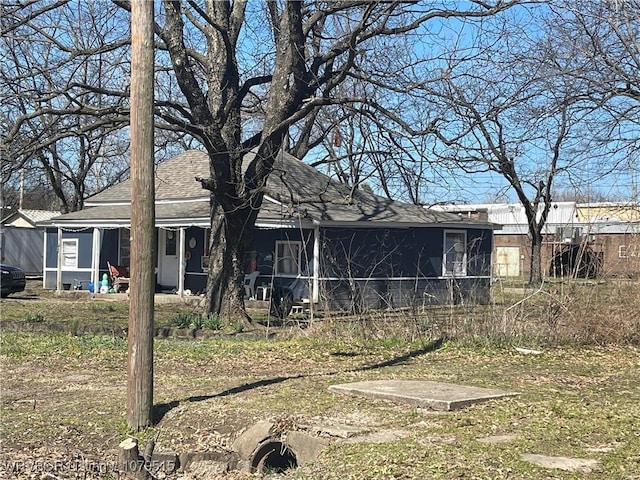 back of house featuring a shingled roof