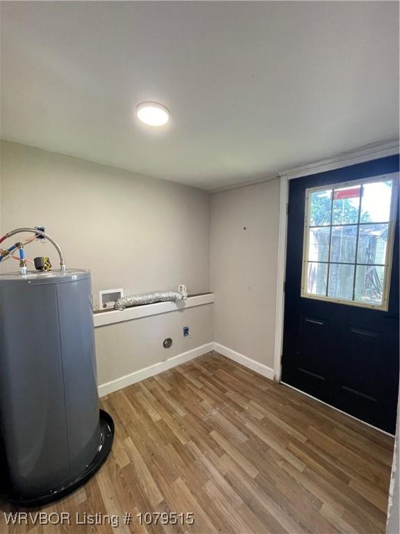 interior space featuring baseboards, light wood-type flooring, and electric water heater