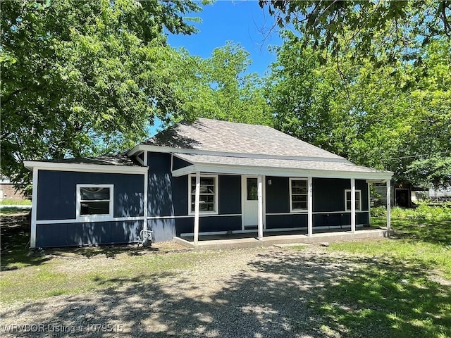 bungalow-style house with a porch and roof with shingles