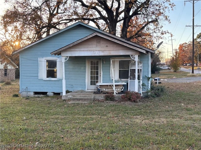 bungalow-style house with covered porch and a front lawn