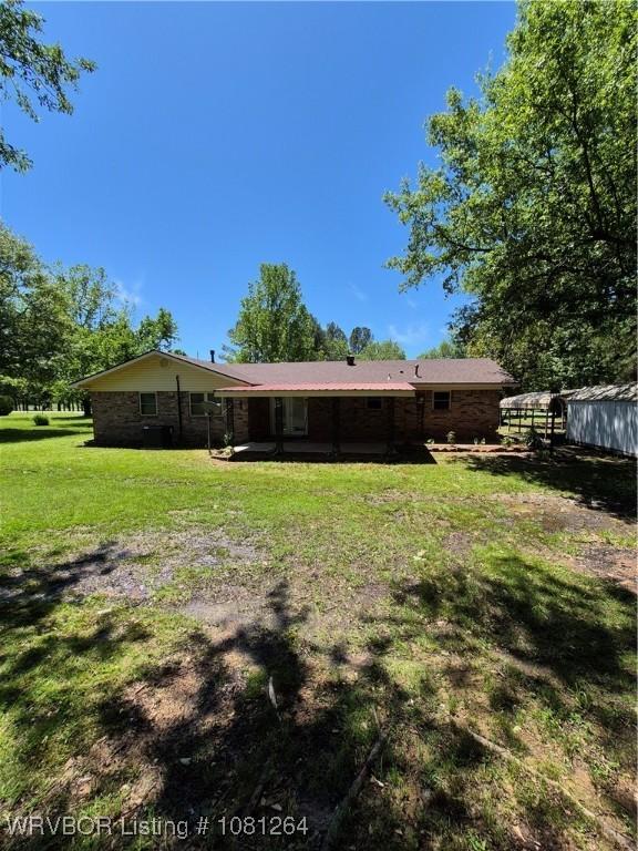 1382 6th St, Waldron, AR 72958 - rear view of property with a yard