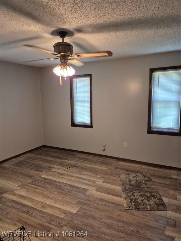 1382 6th St, Waldron, AR 72958 - empty room featuring ceiling fan, a textured ceiling, wood finished floors, and baseboards