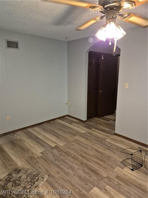 1382 6th St, Waldron, AR 72958 - spare room featuring ceiling fan, wood finished floors, baseboards, and a textured ceiling
