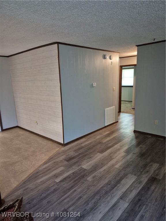 1382 6th St, Waldron, AR 72958 - empty room with a textured ceiling, crown molding, wood finished floors, and baseboards